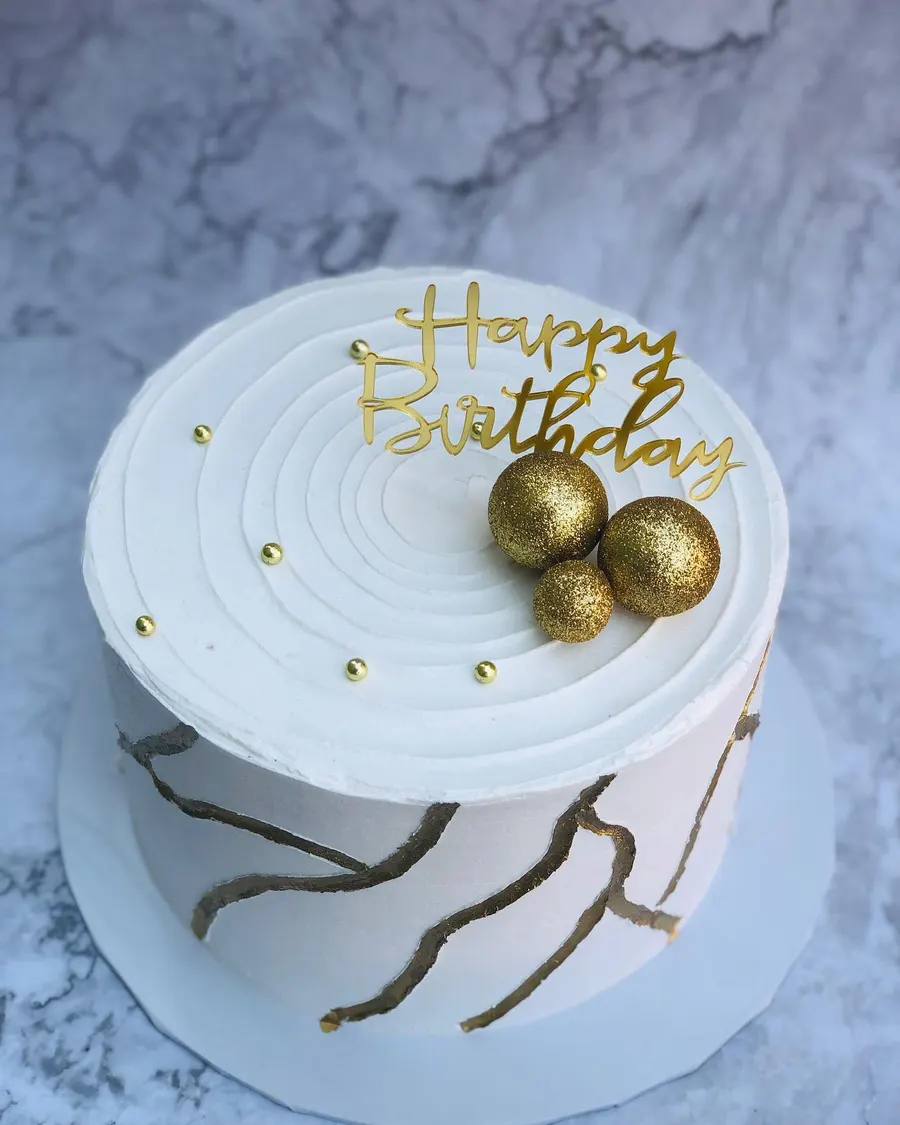 A white and gold birthday cake she made in Lokoja, Nigeria, in 2023