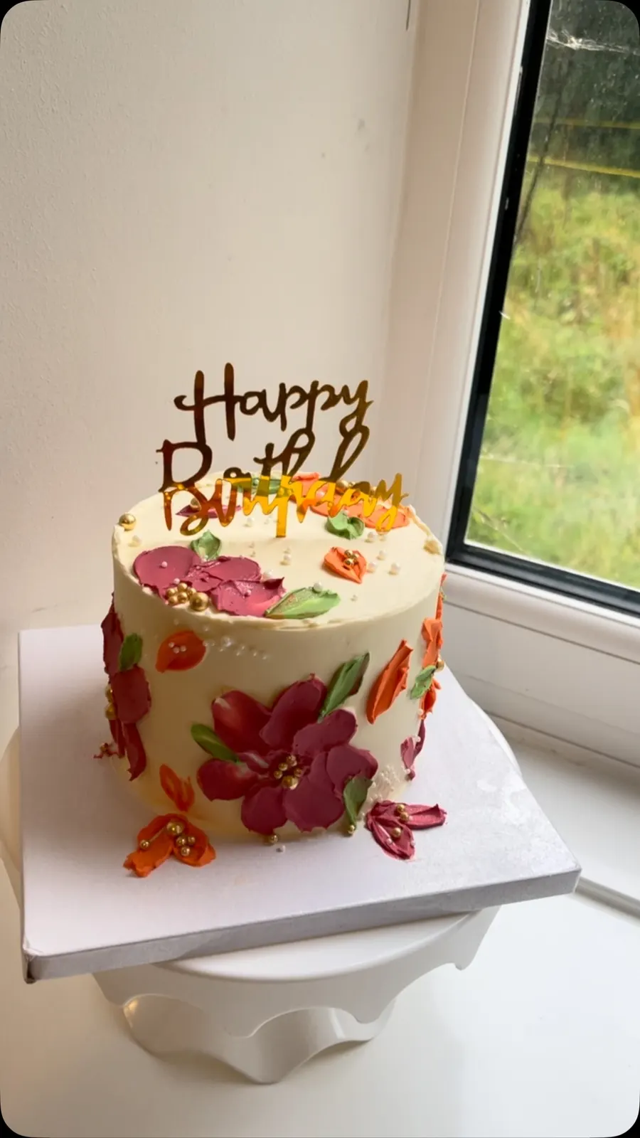 Cream cake with hand-painted red and orange buttercream flowers