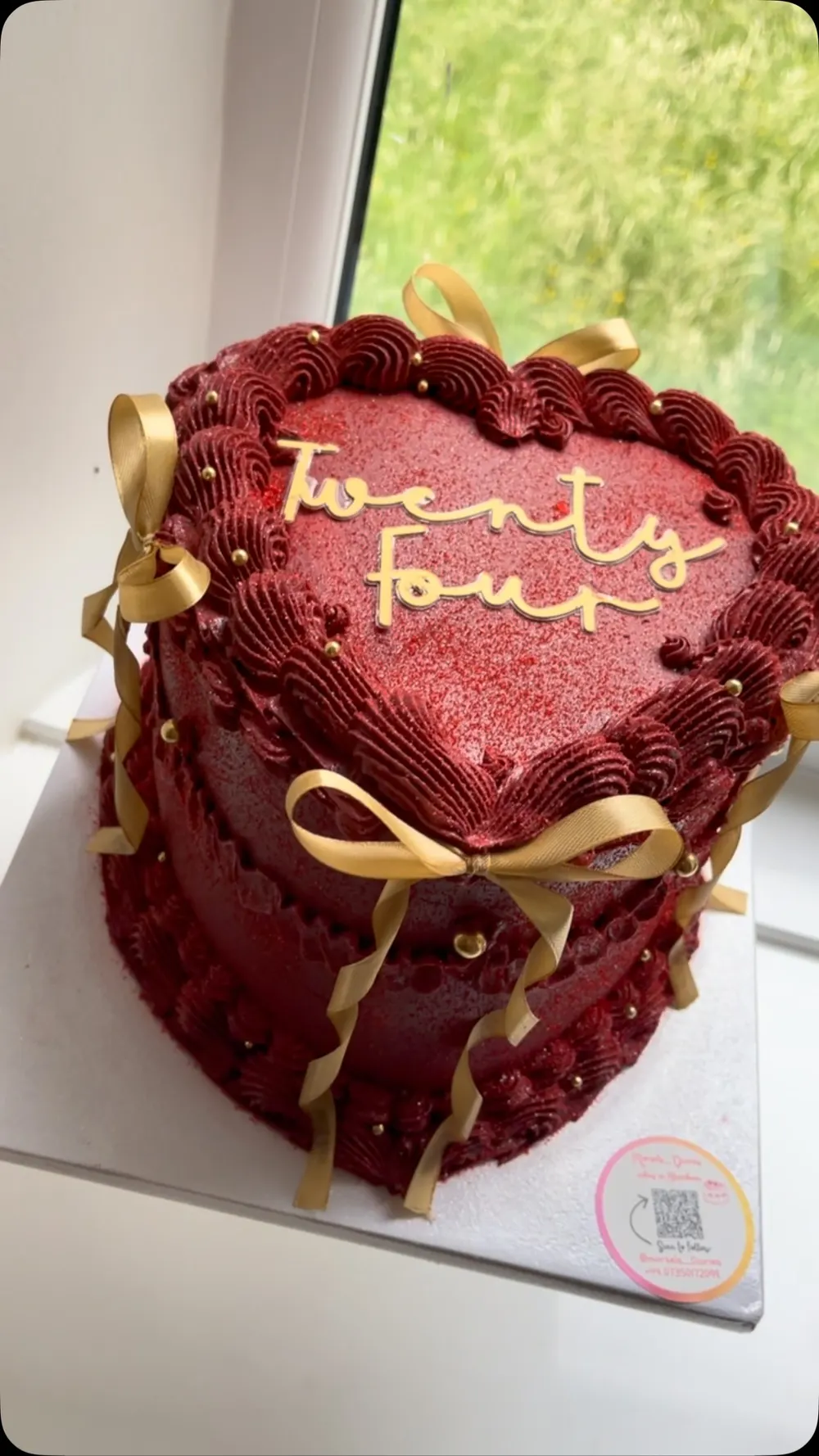 Red velvet heart cake with gold "Twenty Four" lettering and gold ribbon