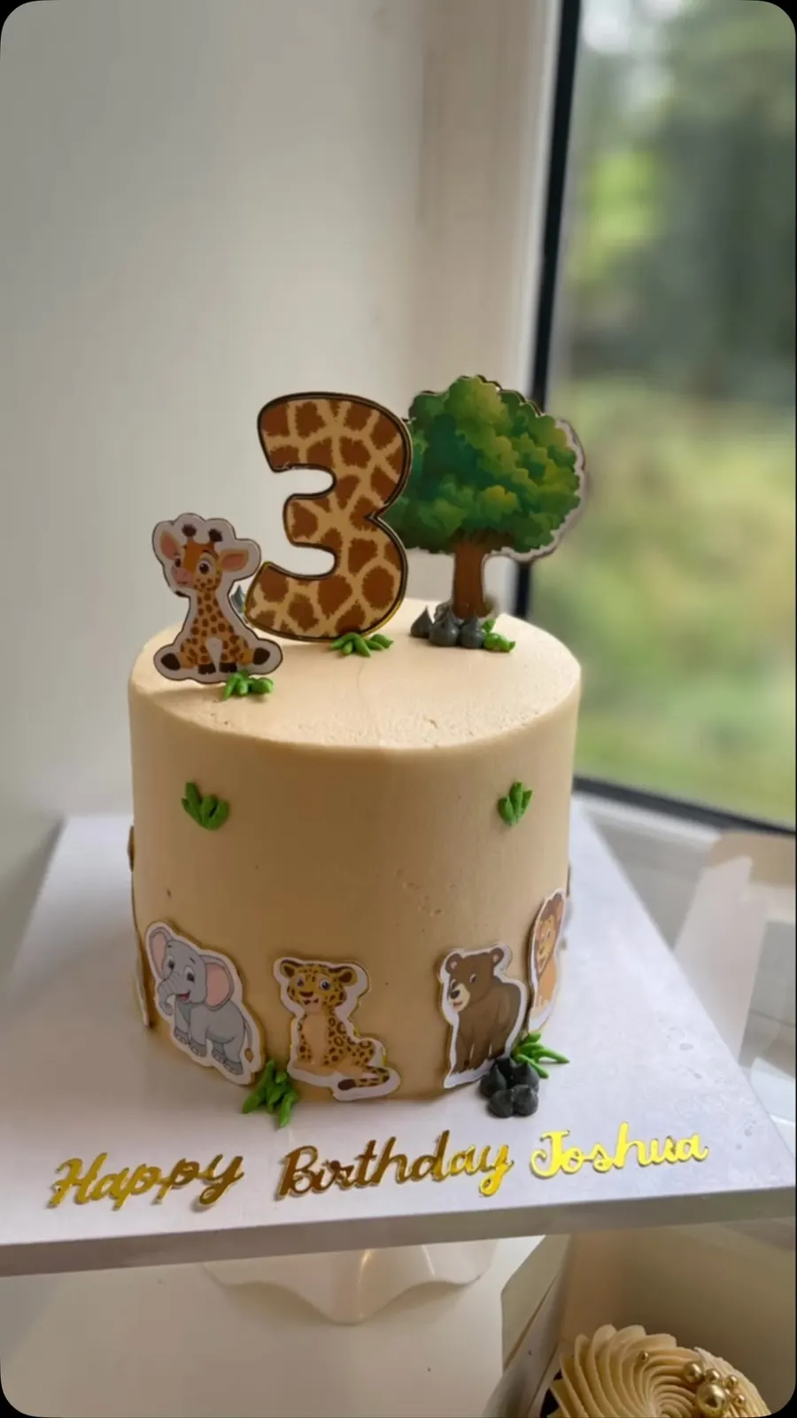 Safari third birthday cake with a giraffe 3 and animal cut-outs