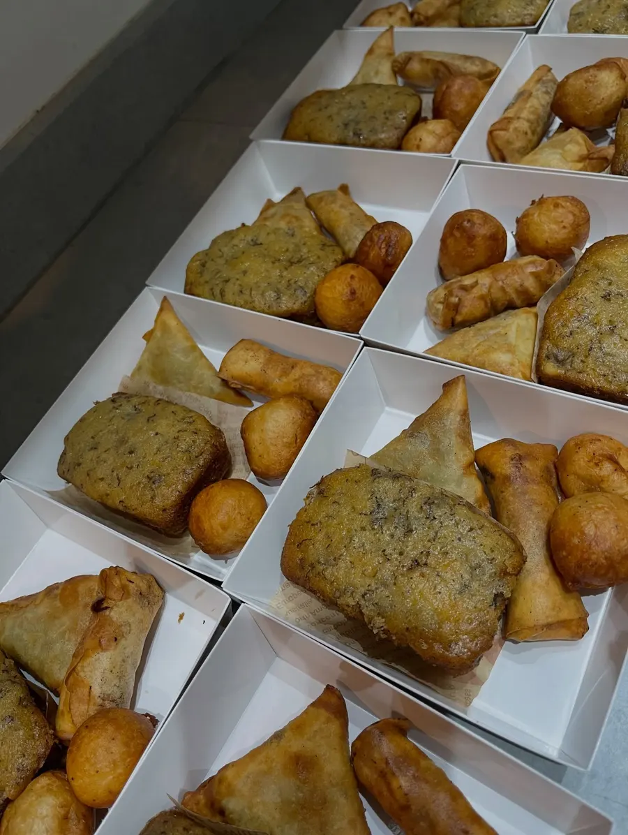 Boxes of golden samosas and spring rolls