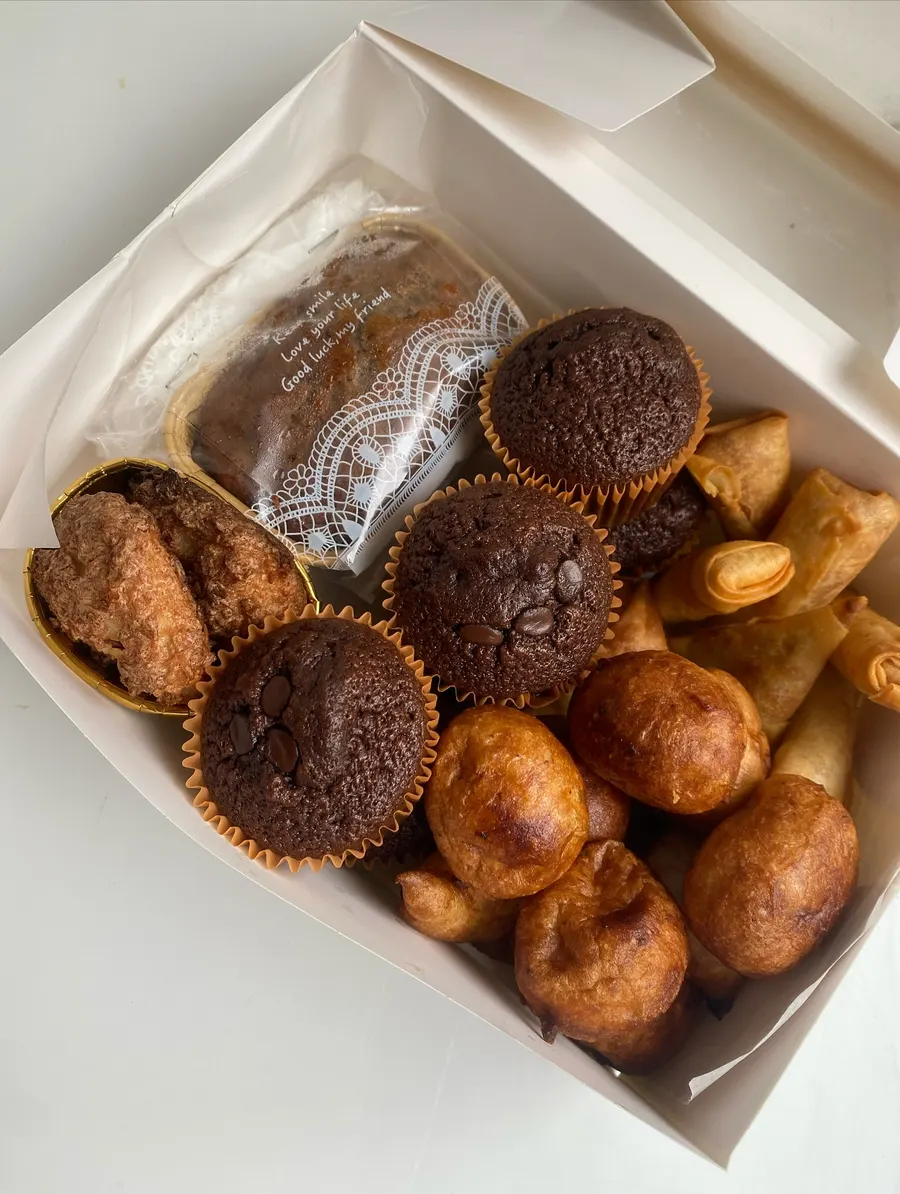 Treat box with chocolate cupcakes, puff puff, samosas and banana bread